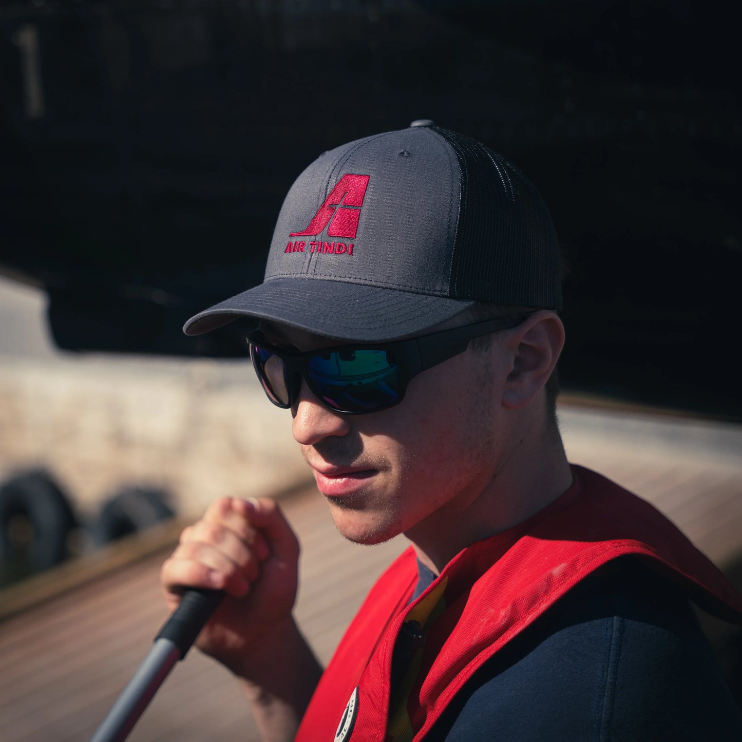 Model wearing an Air Tindi Essential Trucker Cap in Charcoal