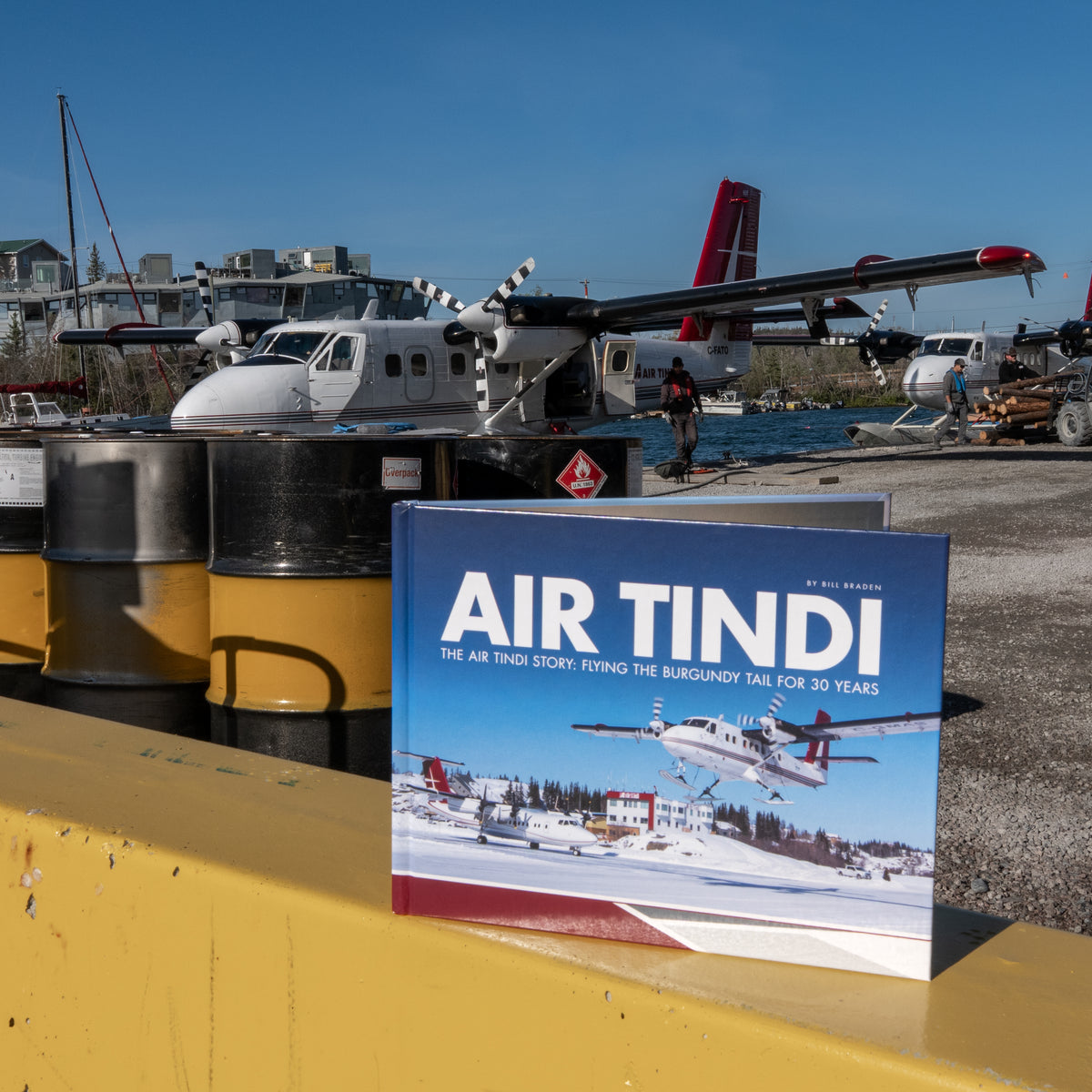 Air Tindi 30th anniversary story book displayed in front of a Twin Otter aircraft in Yellowknife, Northwest Territories.