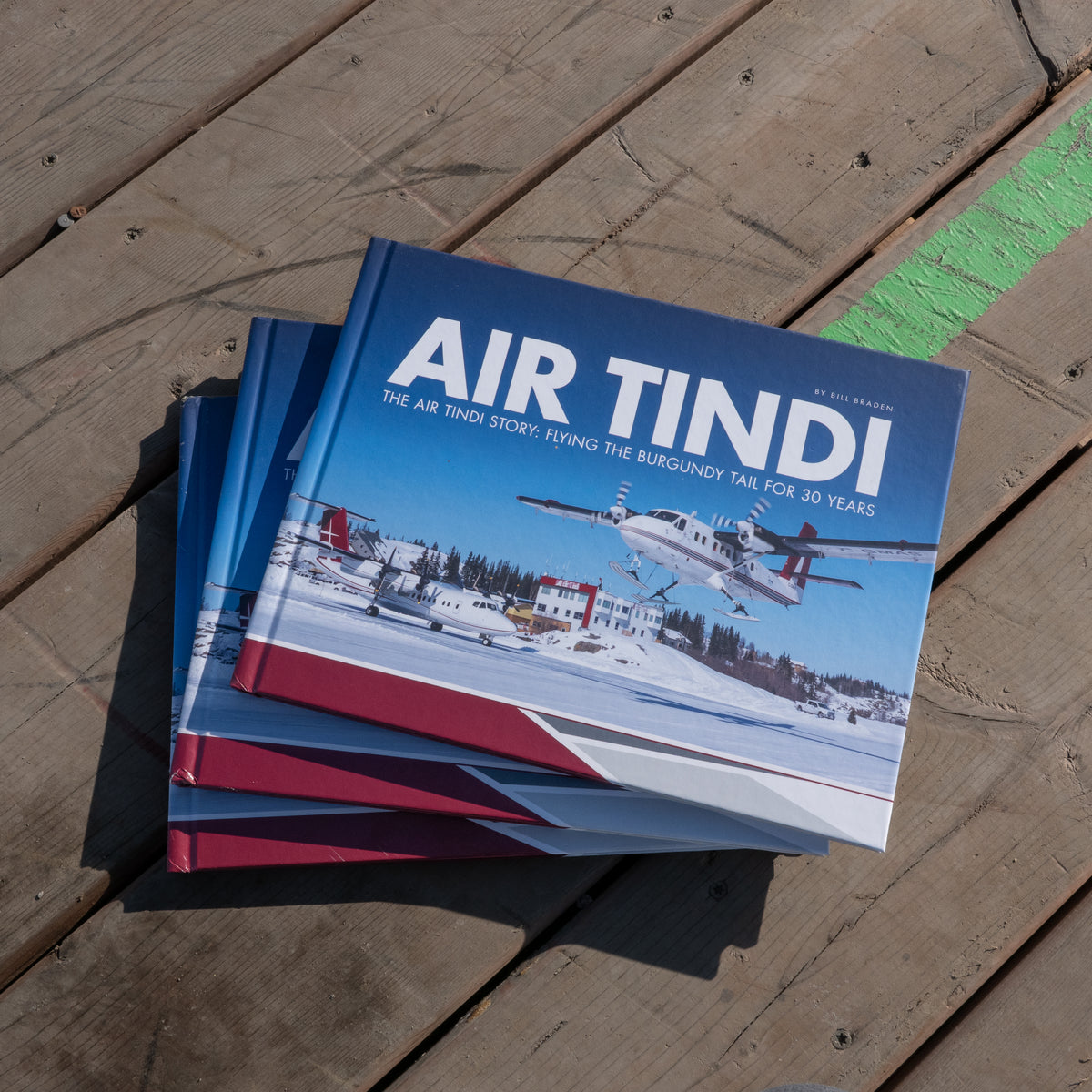 Air Tindi 30th anniversary aviation history books displayed on a wooden deck.