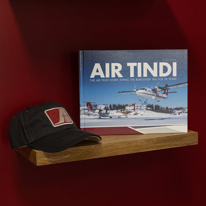Air Tindi 30th anniversary book displayed with the Air Tindi Signature Cap.