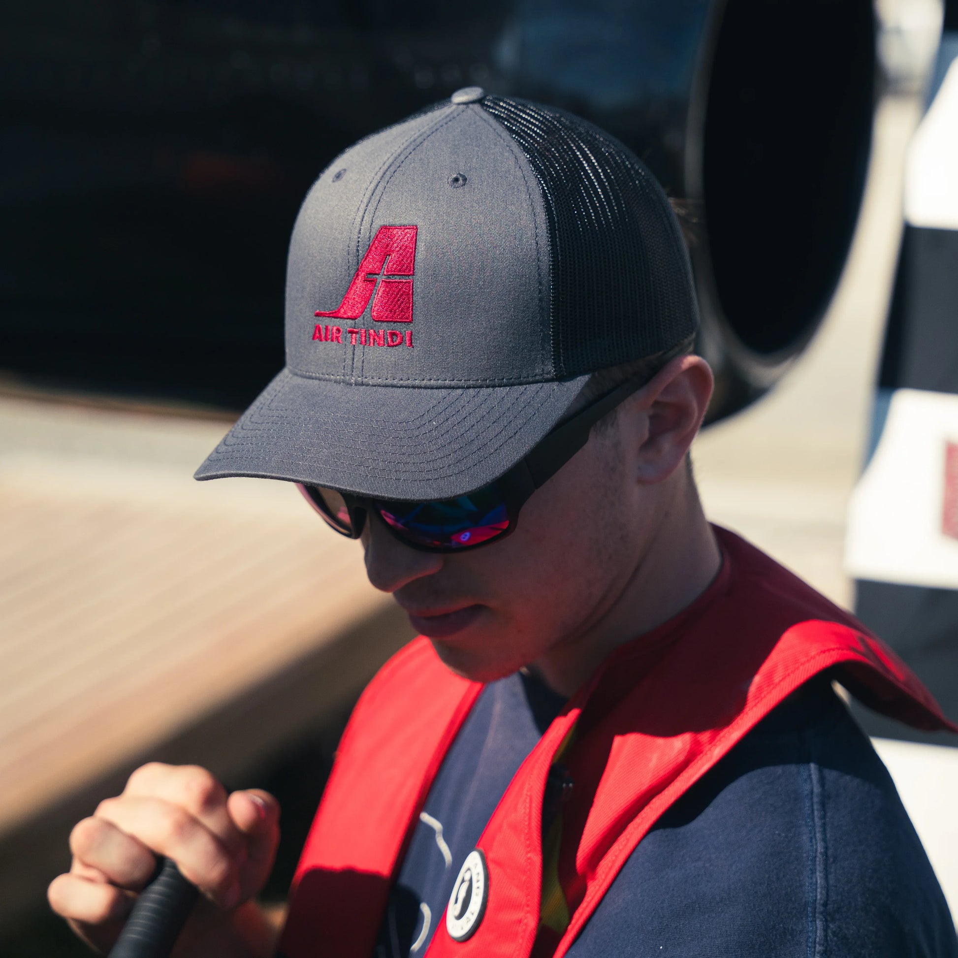 Model wearing an Air Tindi Essential Trucker Cap in Charcoal