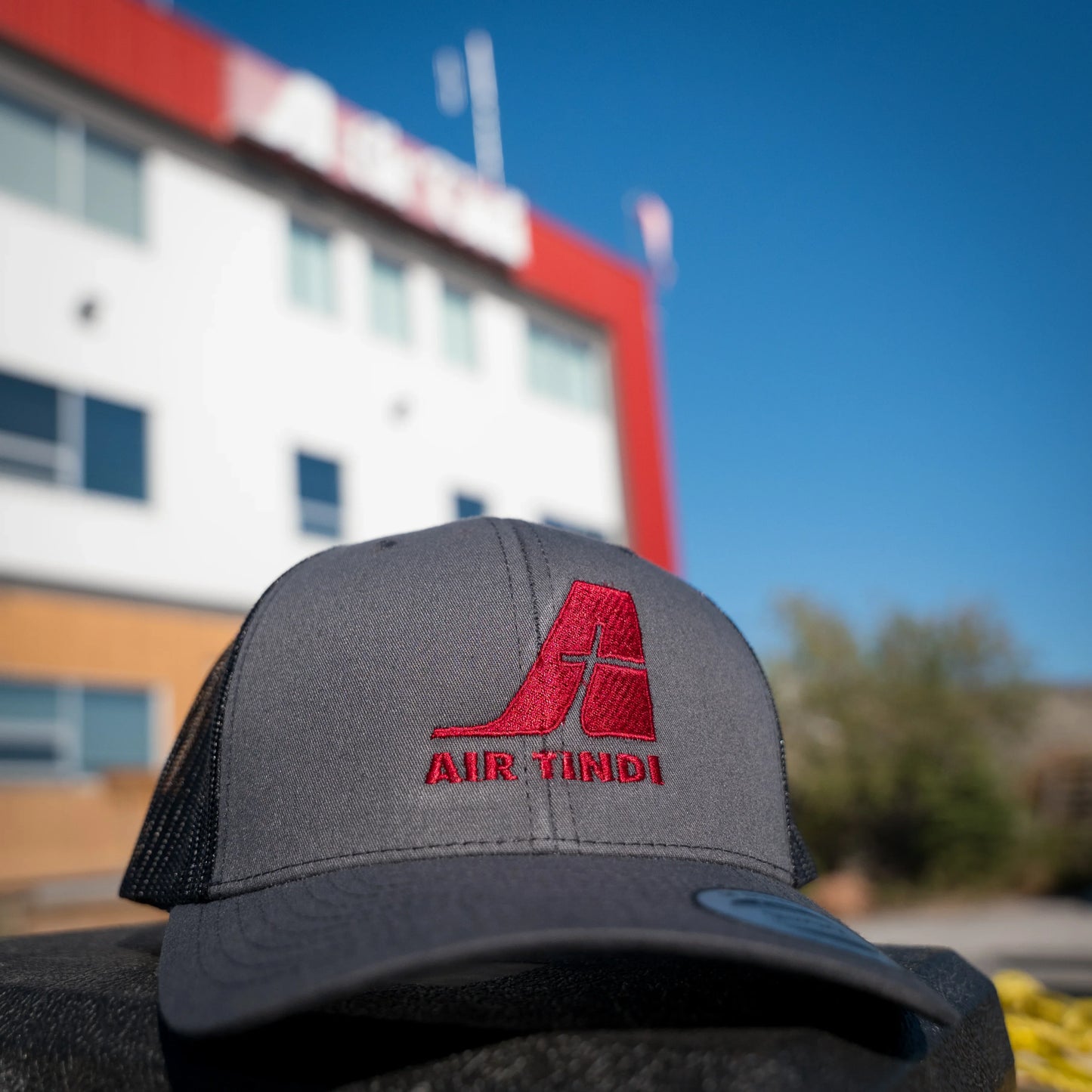 Air Tindi Essential Trucker Cap in Charcoal in front of the Air Tindi Float Base