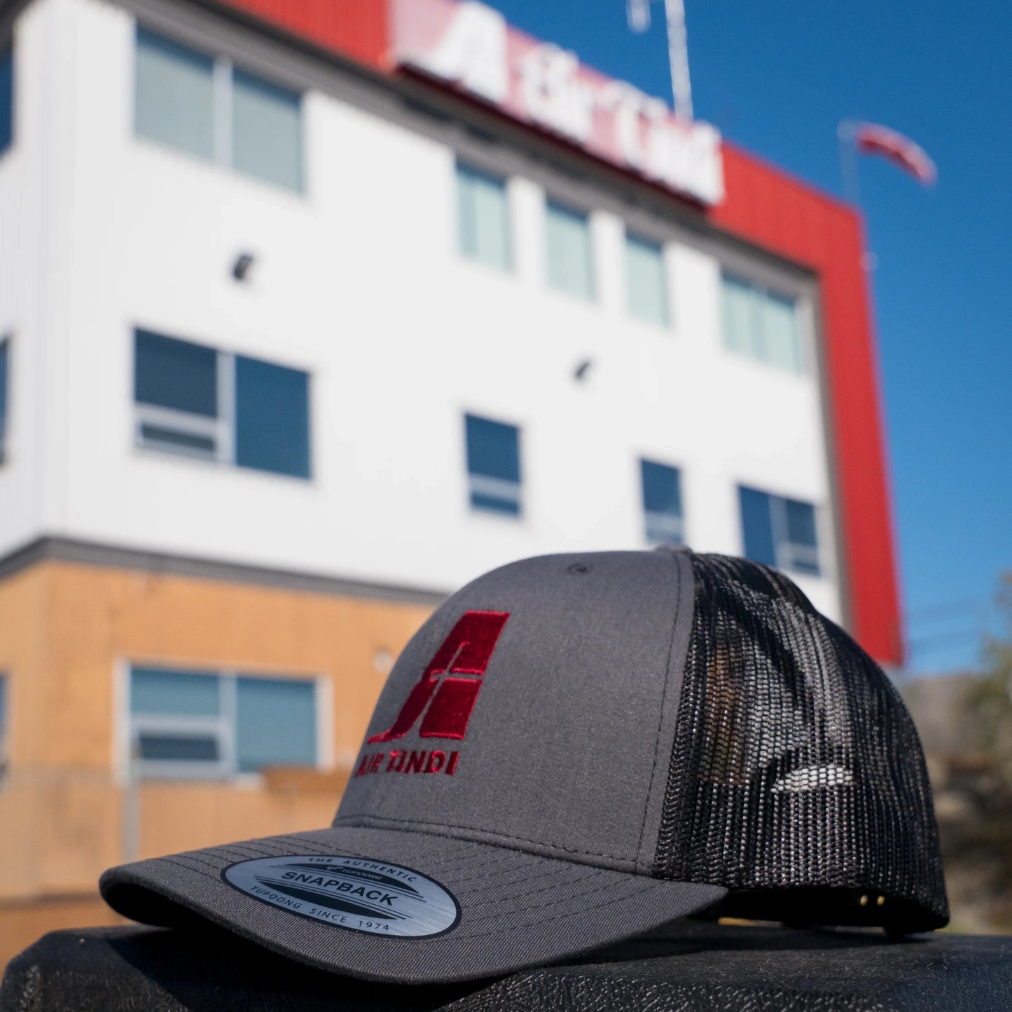 Air Tindi Essential Trucker Cap in Charcoal in front of the Air Tindi Float Base