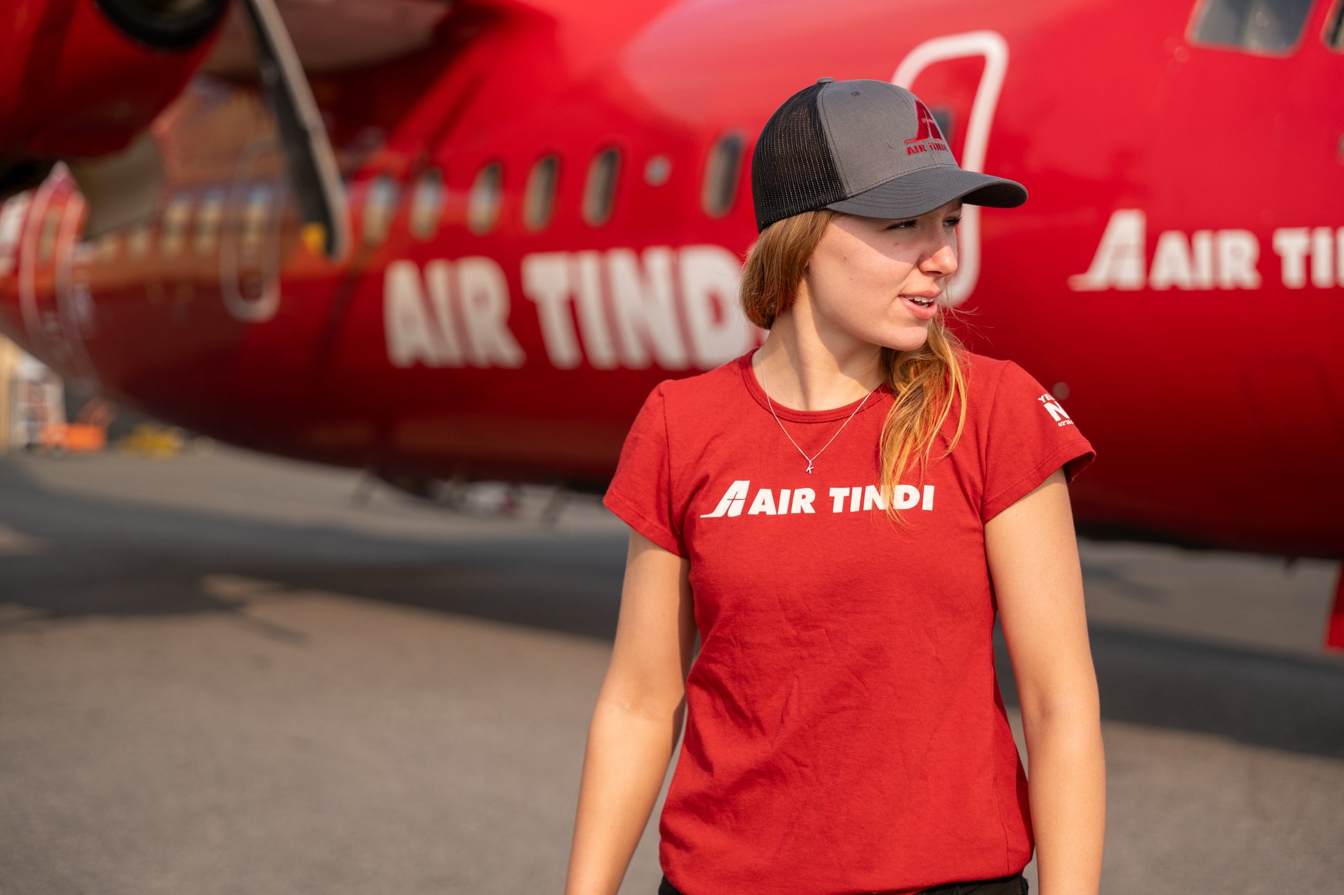 Model wearing an Air Tindi Legacy T-Shirt, alongside an Essential Trucker Cap