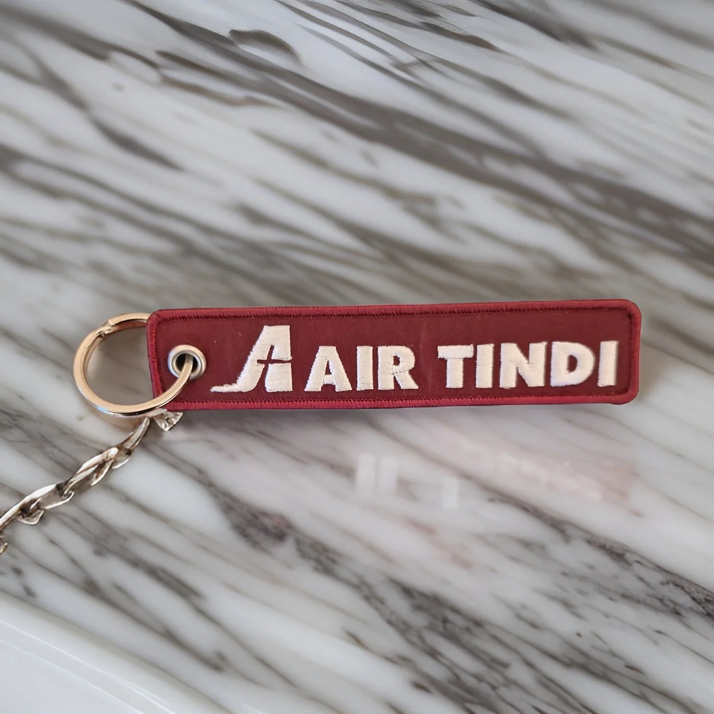 Air Tindi Remove Before Flight Keychain on a countertop