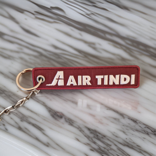 Air Tindi Remove Before Flight Keychain on a countertop