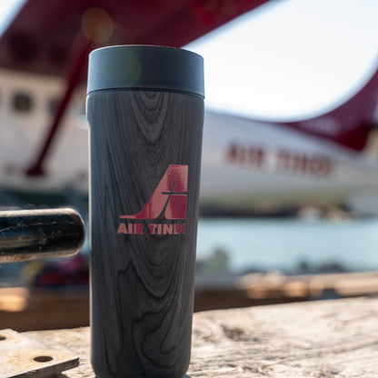 Air Tindi Signature Corkcicle Commuter Cup in Burnt Wood in front of a floatplane