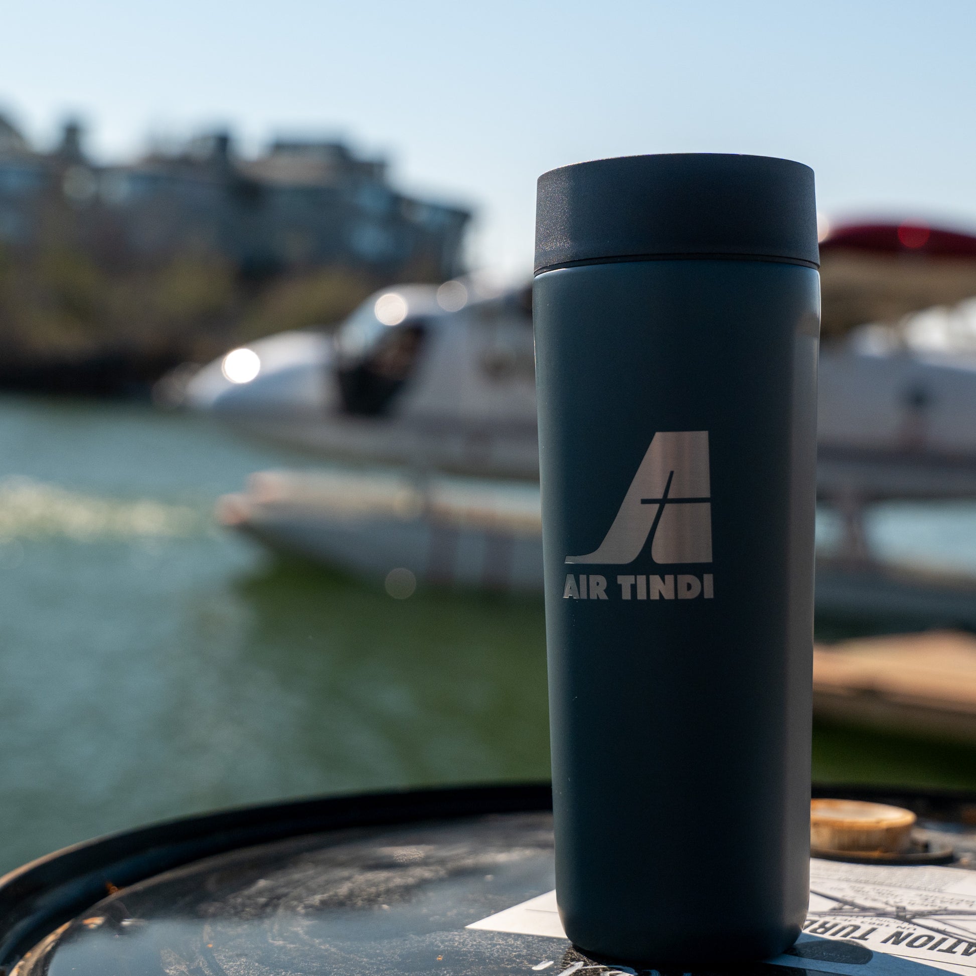 Air Tindi Signature Corkcicle Commuter Cup in Rucksack in front of a floatplane