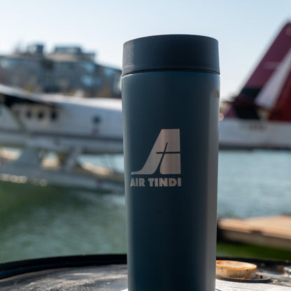 Air Tindi Signature Corkcicle Commuter Cup in Rucksack in front of a floatplane