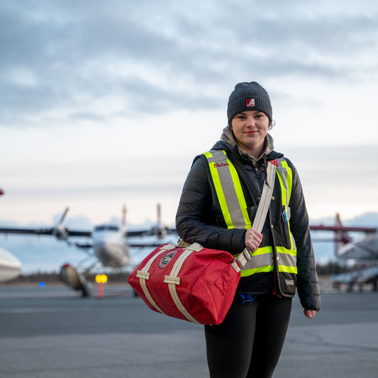 Model carrying an Air Tindi Travel Stow Bag while wearing an Essential Wool Winter Toque