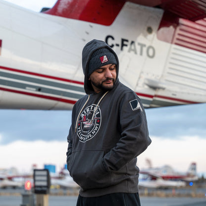 Model wearing an Air Tindi Twin Otter Hoodie in front of a plane